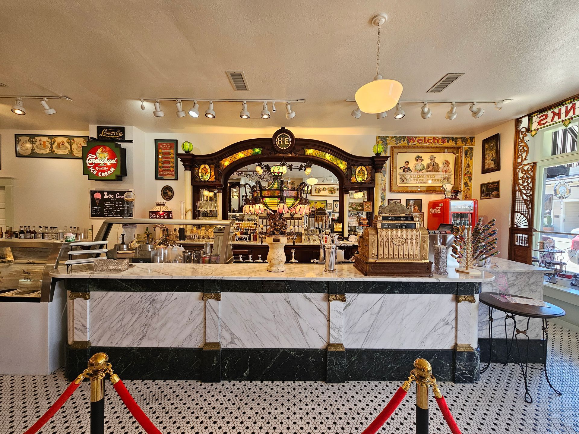 A restaurant with a long counter and a red rope barrier