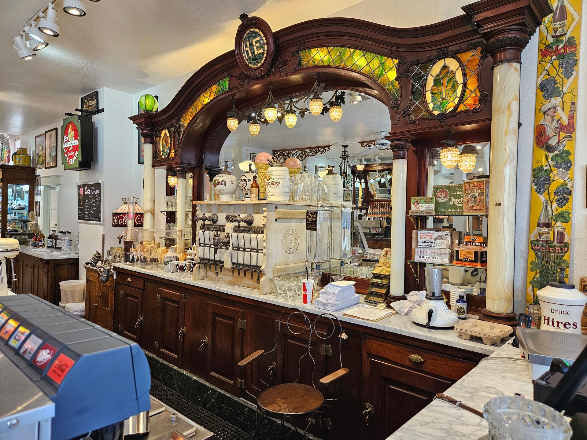 A long counter in a restaurant with a clock on top of it.