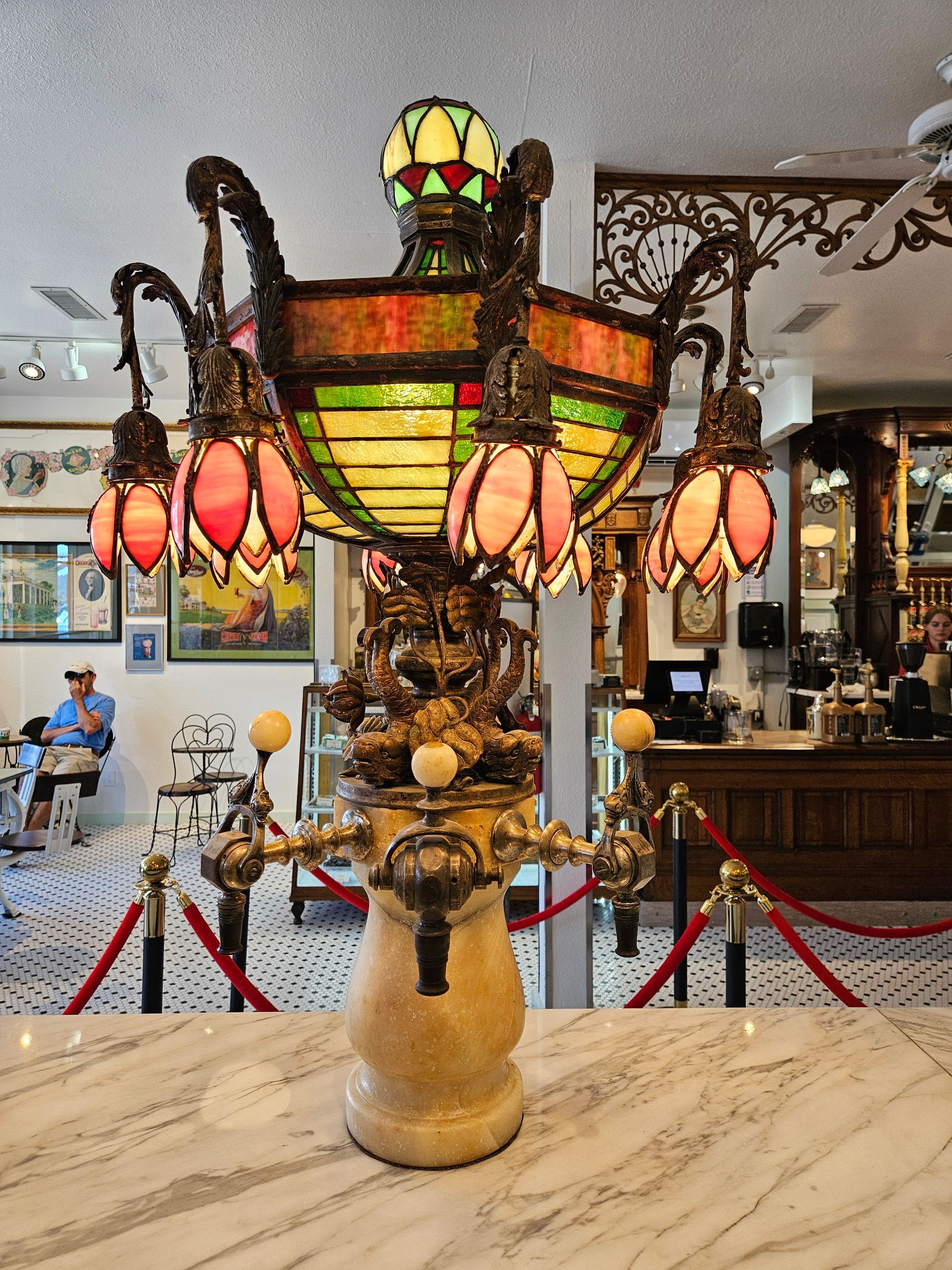 A stained glass lamp is sitting on a counter in a restaurant
