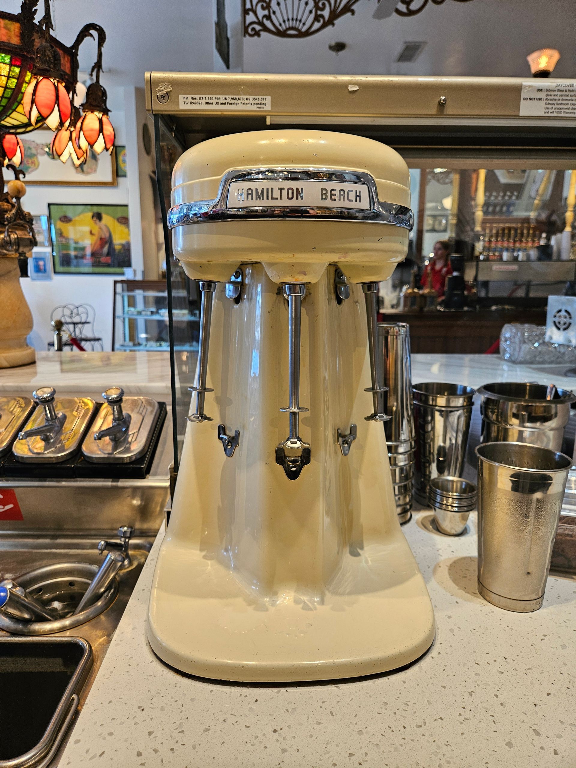 A milkshake maker is sitting on a counter in a restaurant.