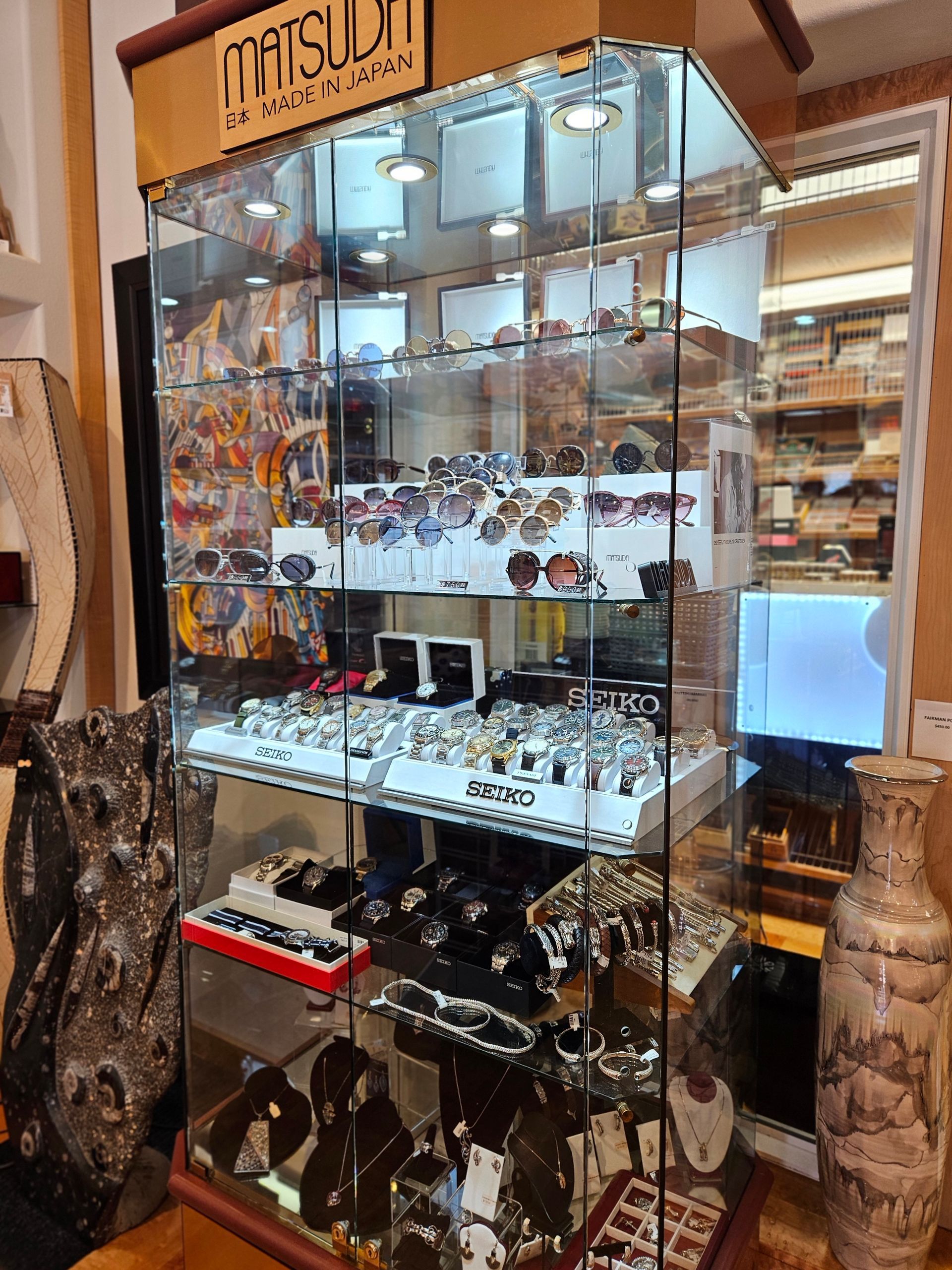 A store display case filled with lots of jewelry and sunglasses