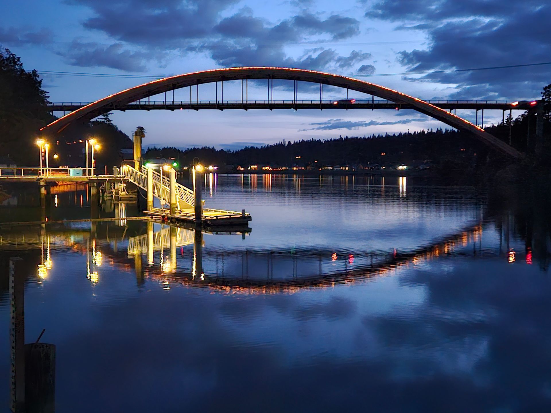Rainbow bridge in La Conner, Washington at dusk with the reflection of the bridge in the water.