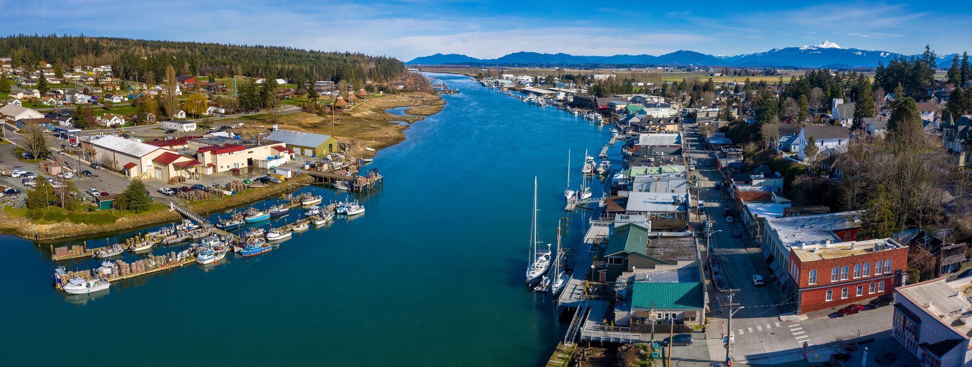 An aerial view of a harbor with boats docked and a city in the background.