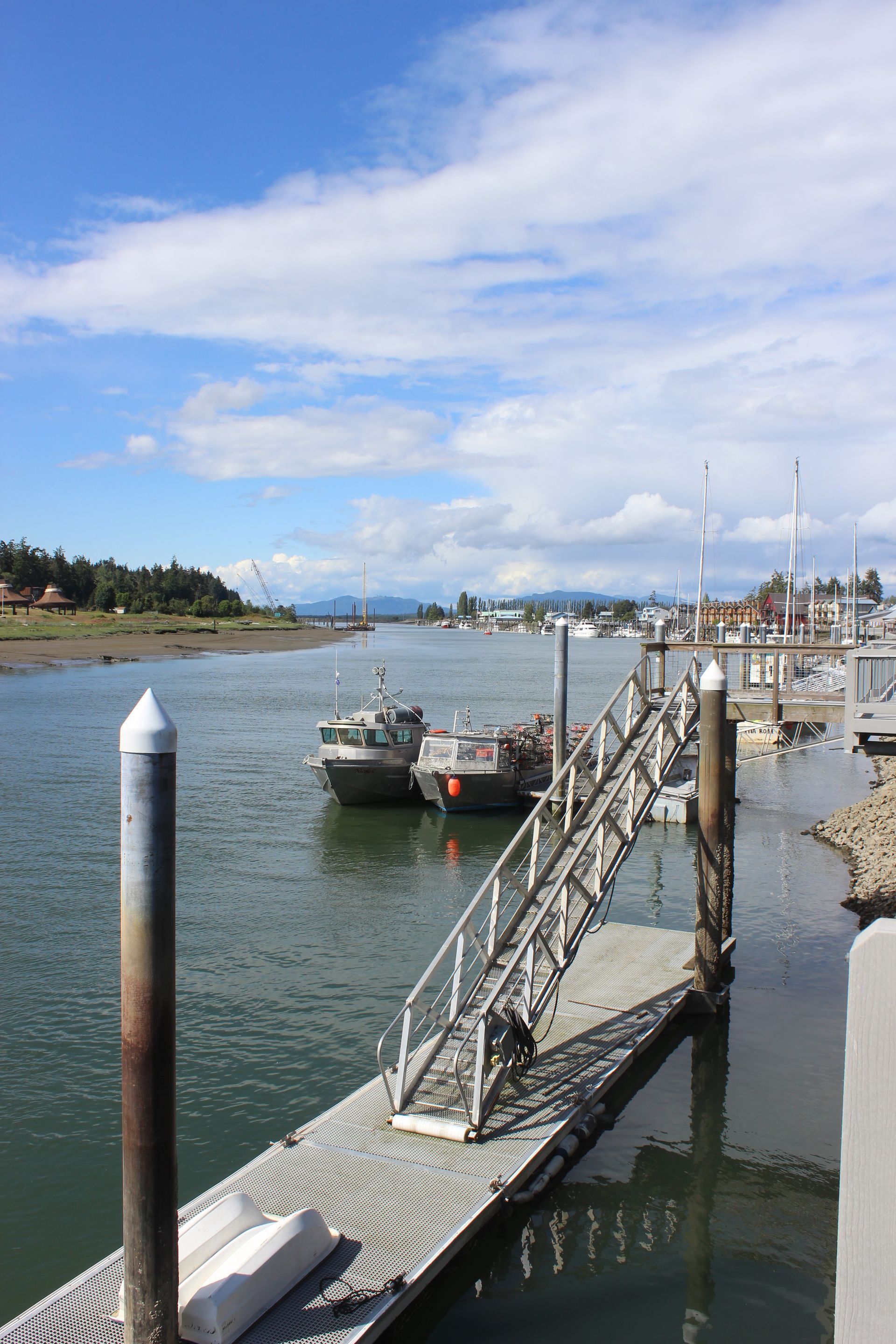 A dock with boats docked in the water on a sunny day.