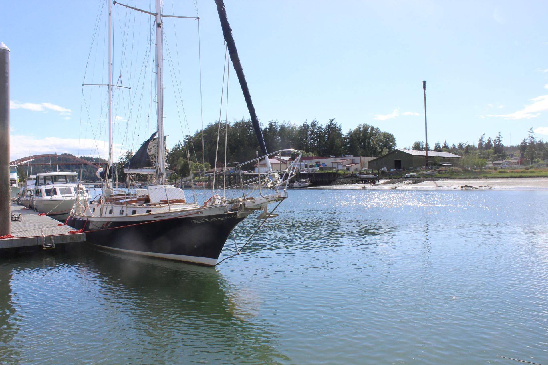 A sailboat is docked in a harbor next to a dock.