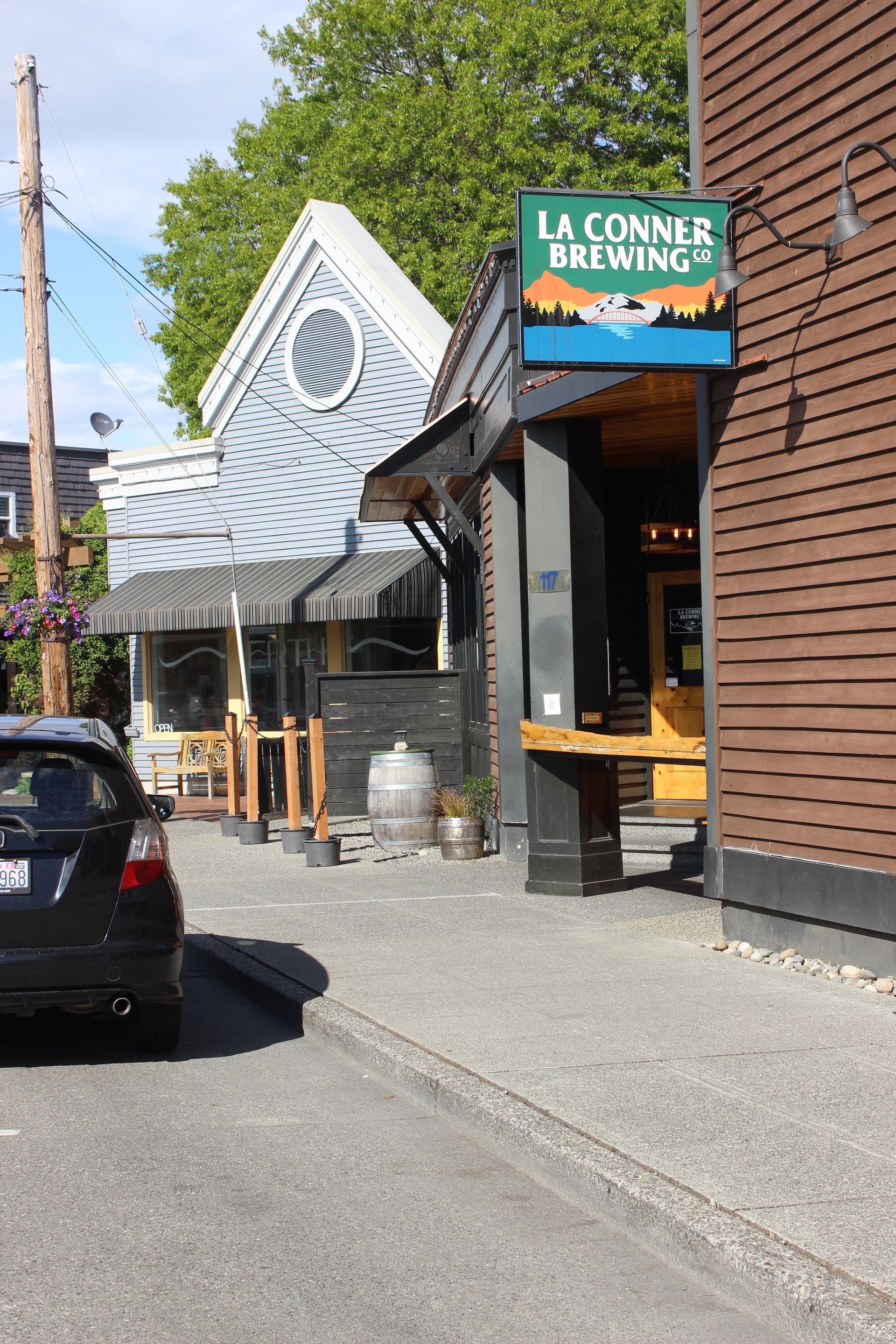 A car is parked in front of a la conner brewing sign