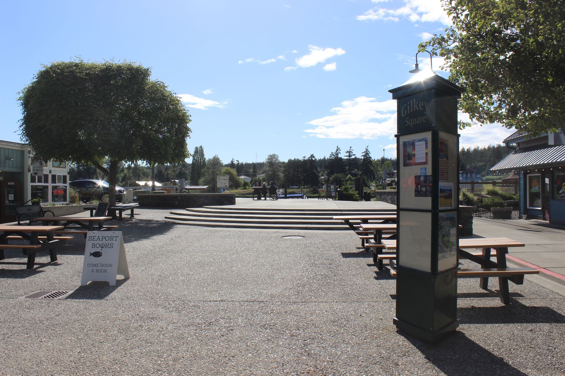 A telephone booth in a park with a sign that says ' no parking ' on it
