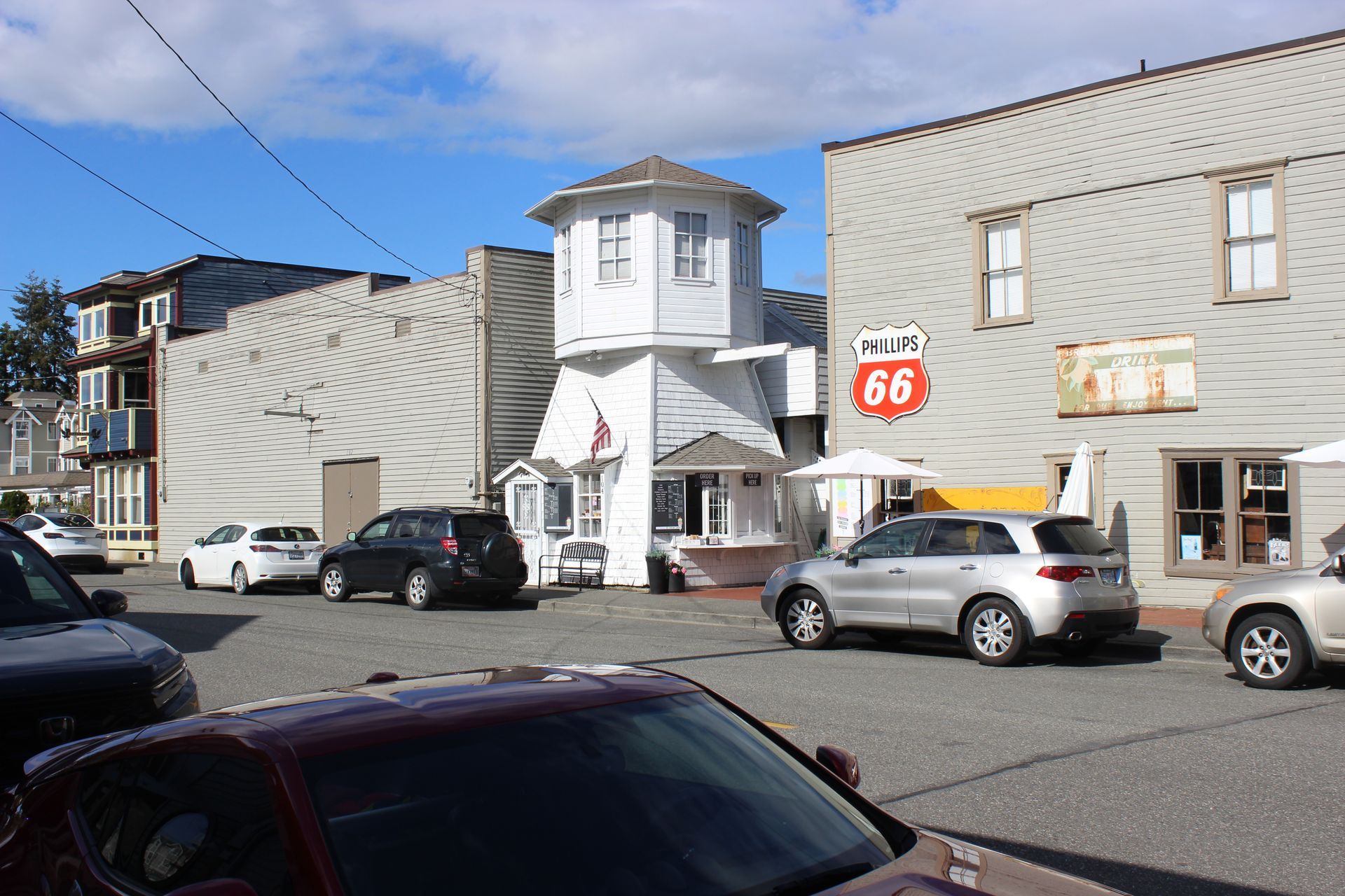 A red car is parked in front of a building with the number 66 on it