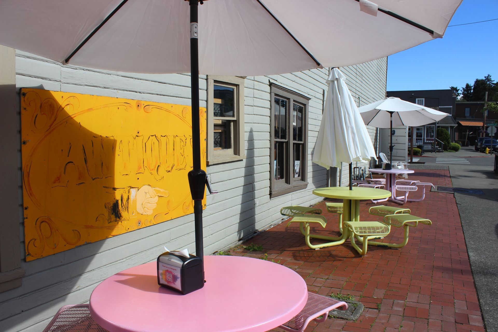 A pink table with an umbrella in front of a building