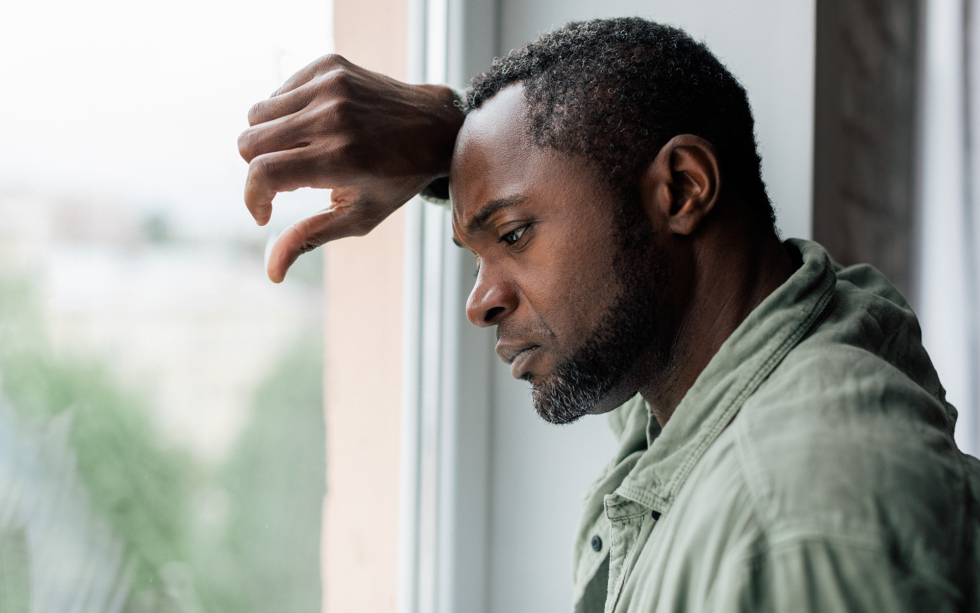 A man is comforting a young man who is sitting in a chair.