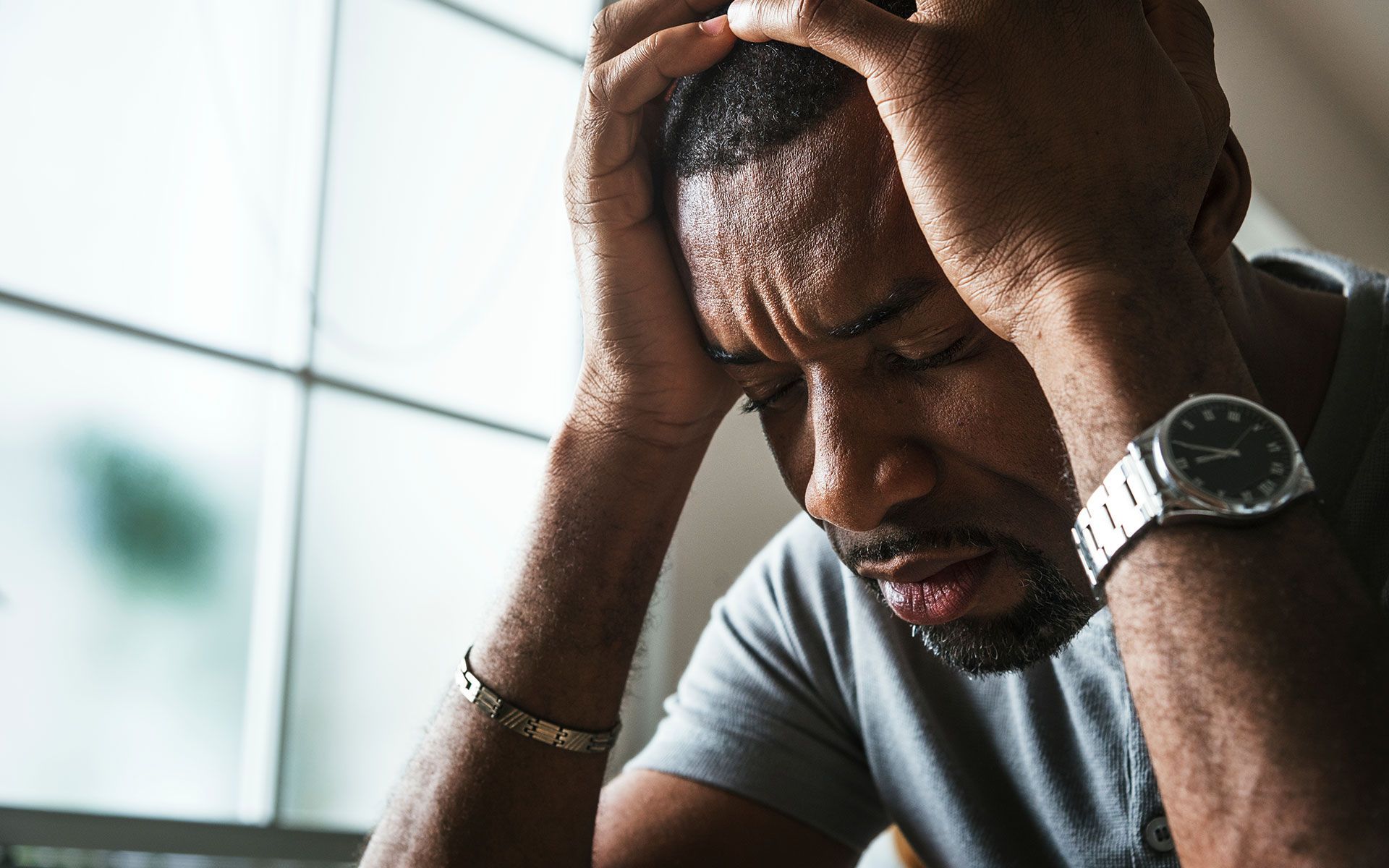 A man is sitting at a table talking to a person holding a clipboard.