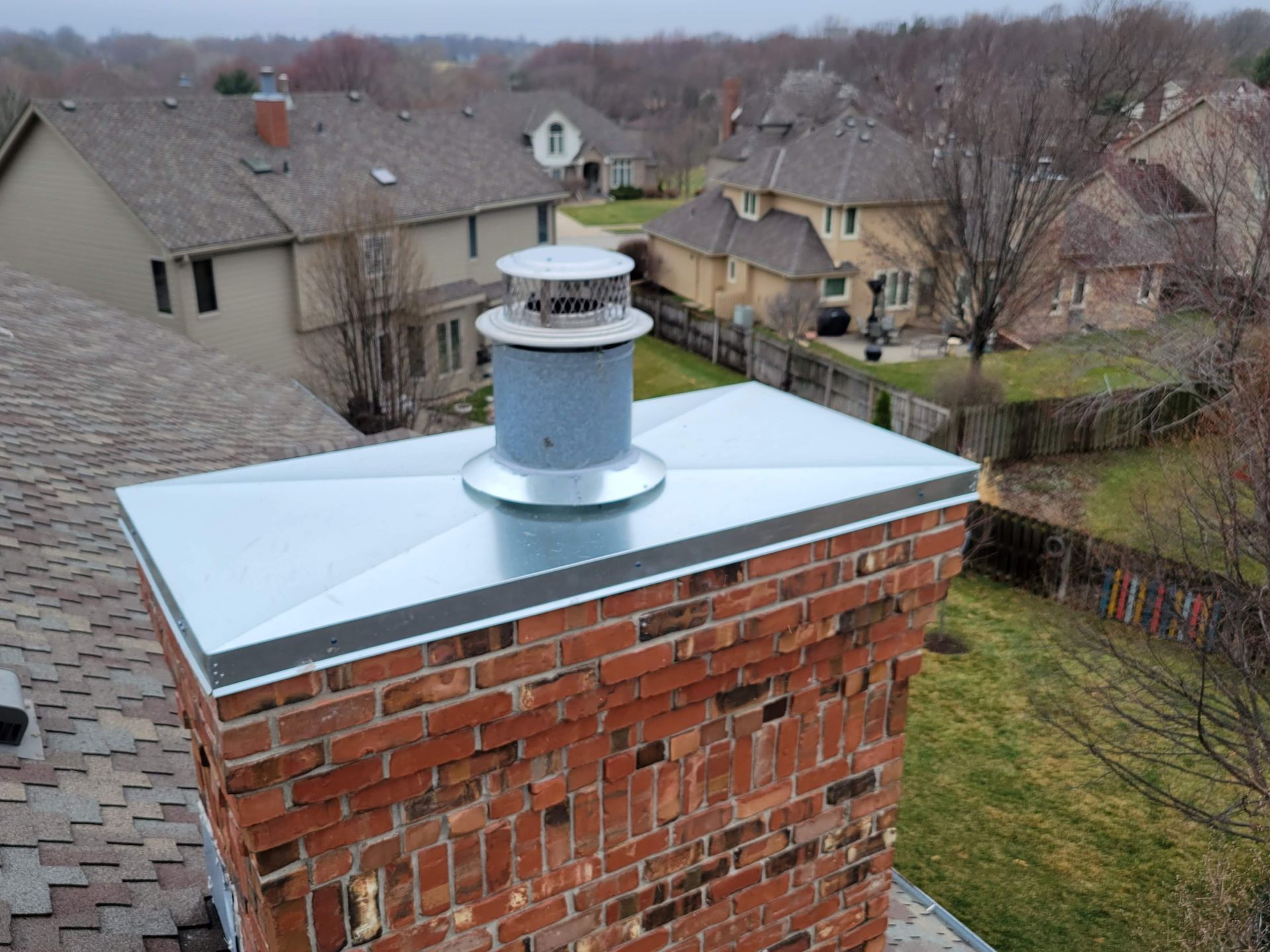 a brick chimney with a metal cap on top of it .