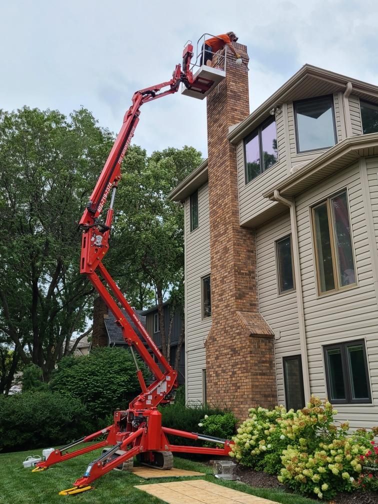 a man is sitting on top of a roof fixing a chimney .
