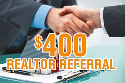 Two people shaking hands over a realtor referral