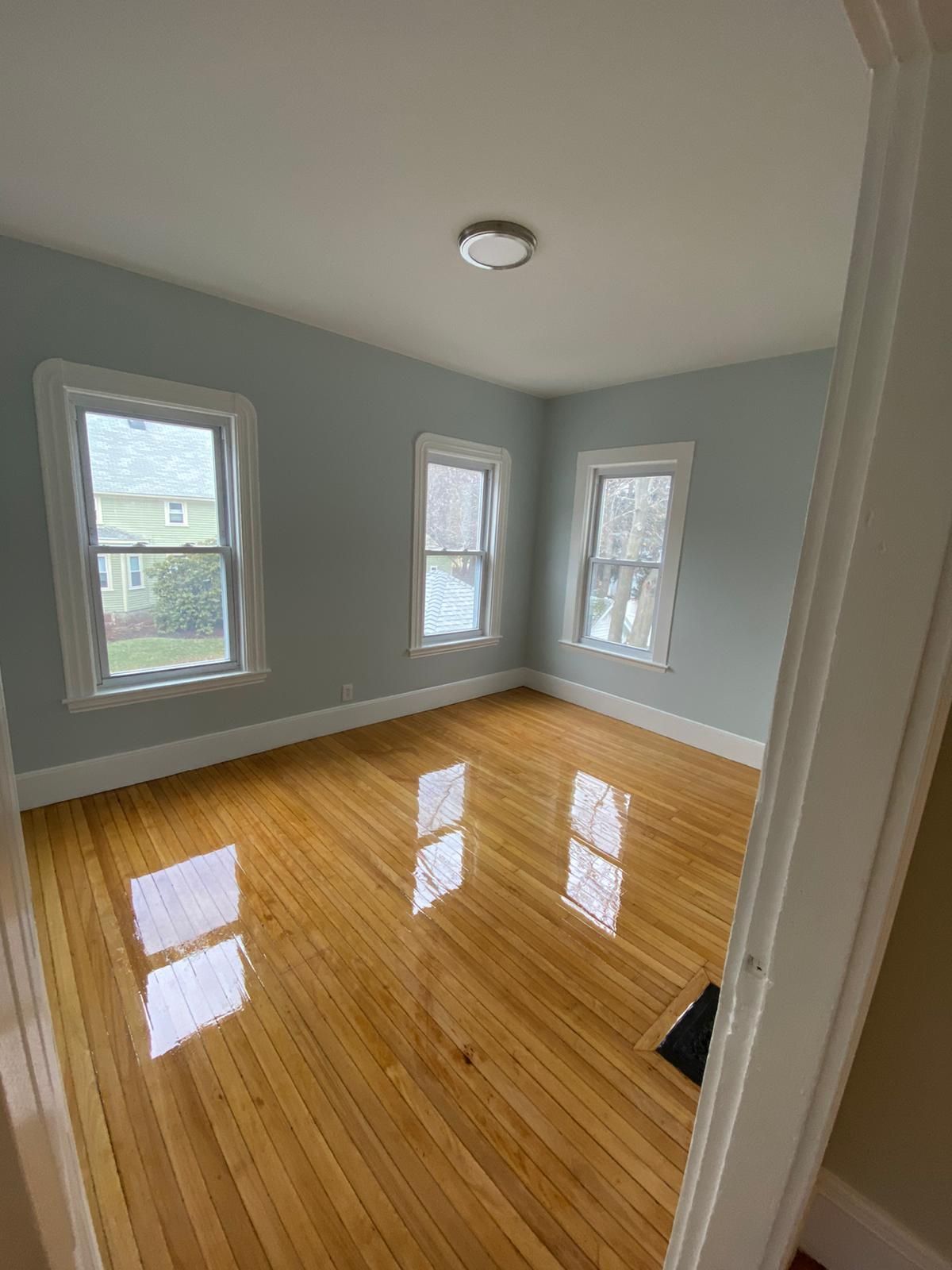 A room with hardwood floors and a lot of windows.