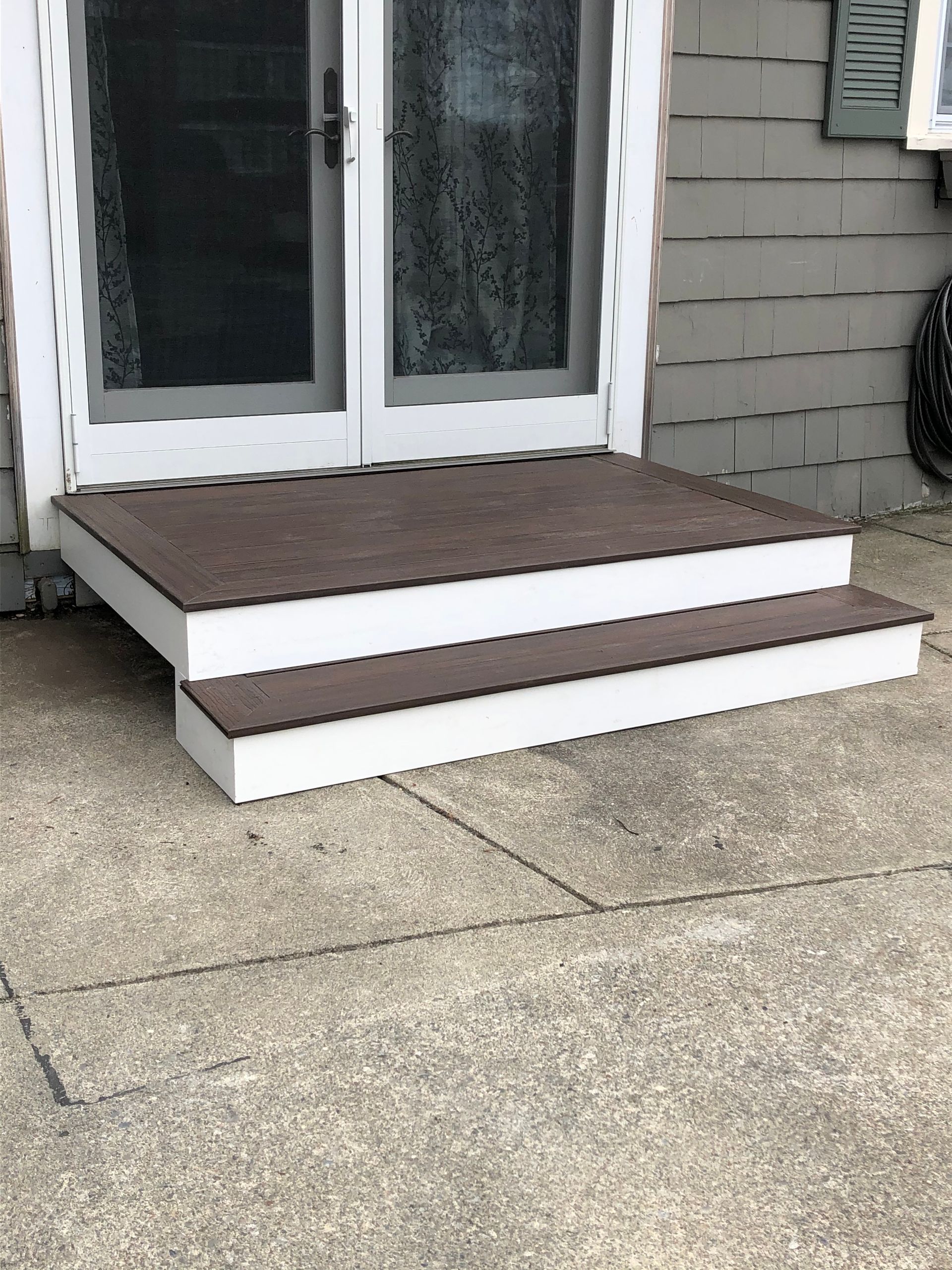 A set of wooden steps leading up to a door of a house.