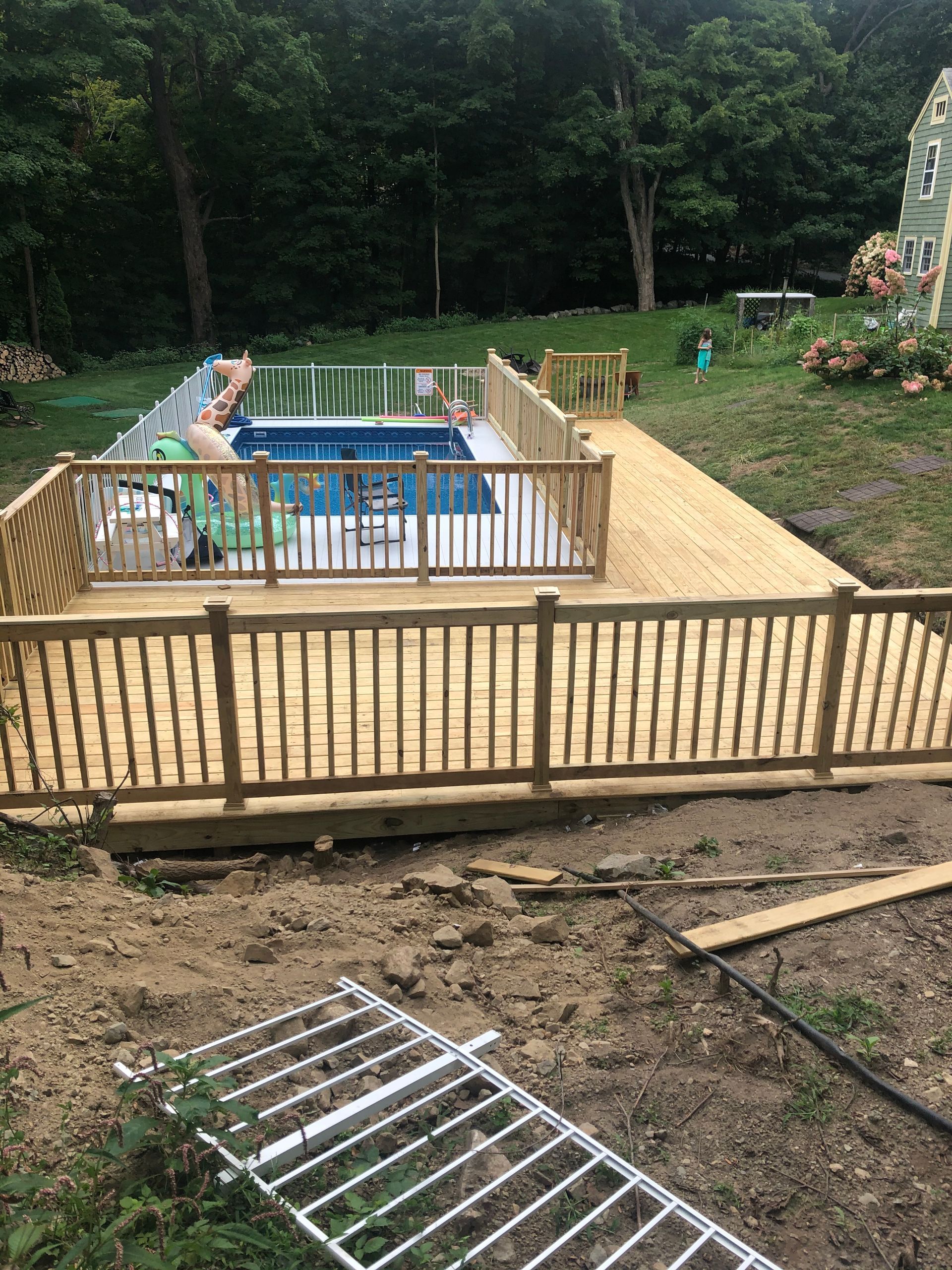A wooden deck is being built around a swimming pool.