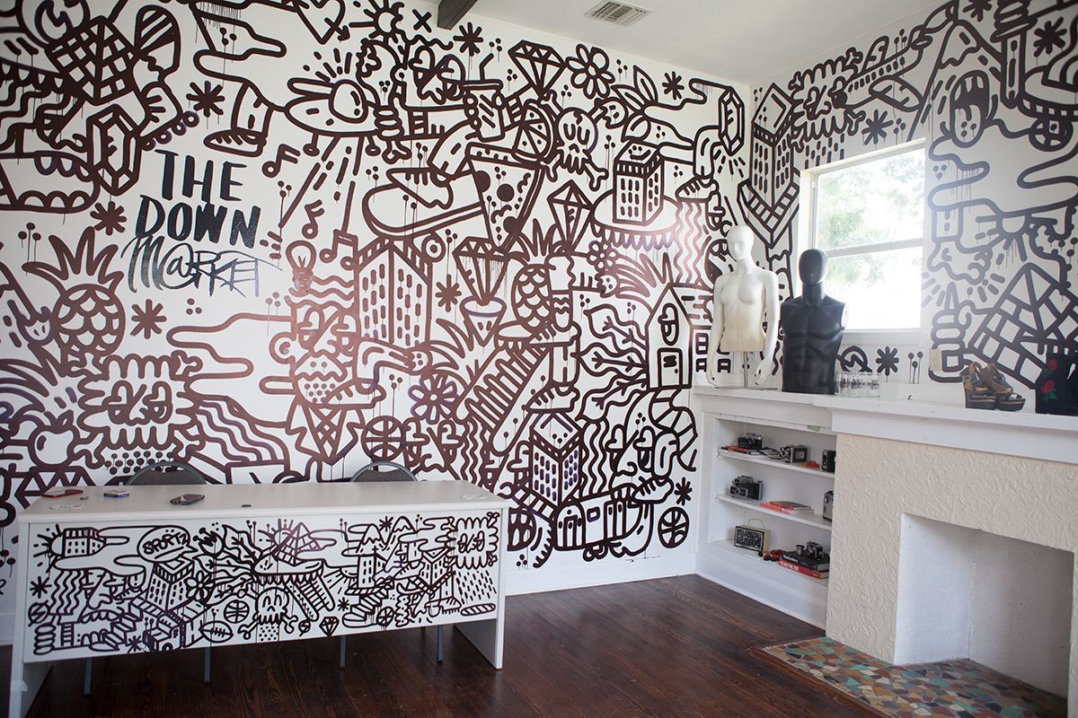 A room with a mural on the wall that says the down