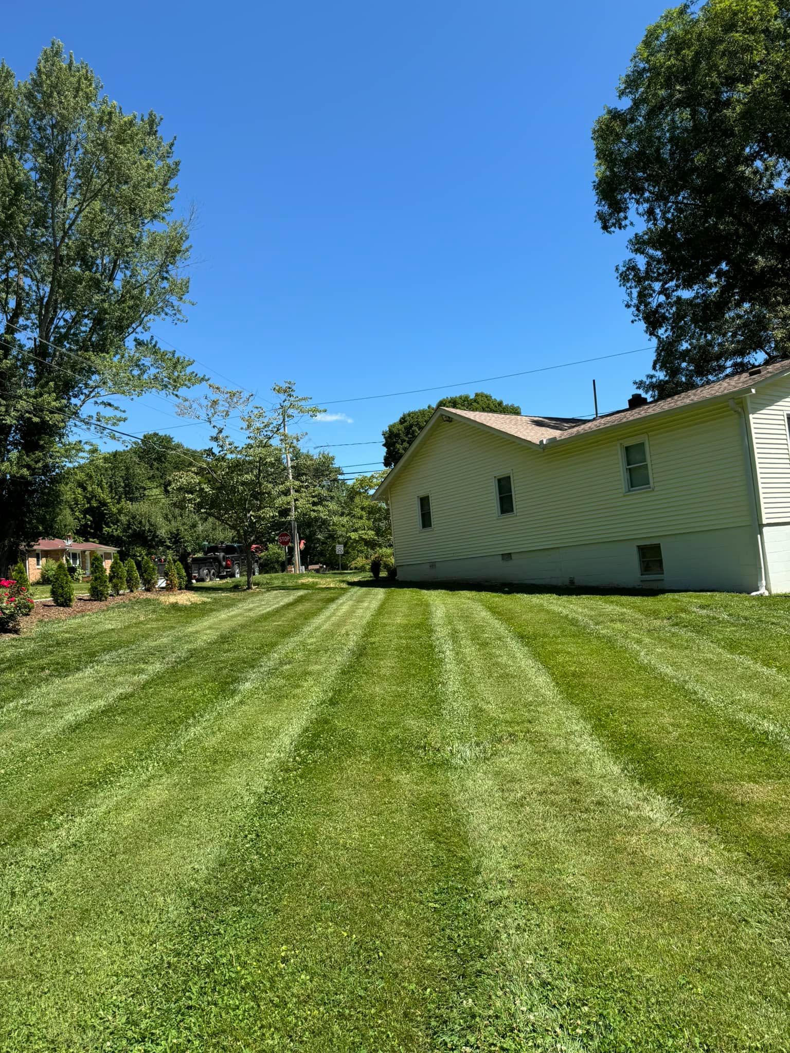 A house with a lush green lawn in front of it.