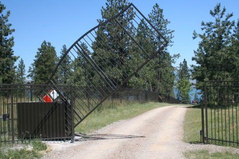 A broken gate on the side of a dirt road
