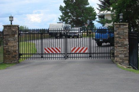 A blue truck is parked behind a metal gate