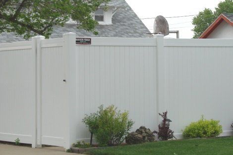 A white fence with a gate in front of a house