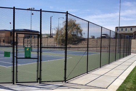 A tennis court with a chain link fence around it