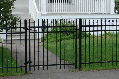 A black fence with a gate in front of a house