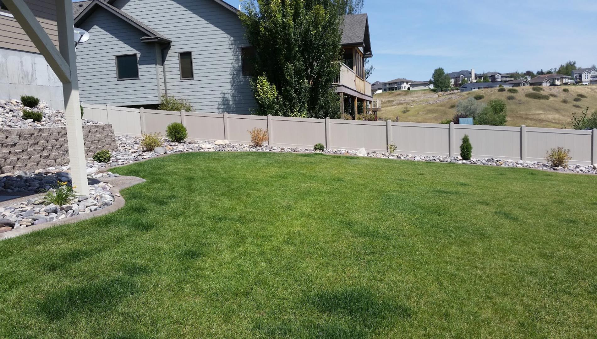A large lush green lawn in front of a house.