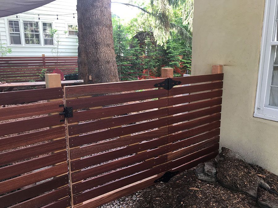 A wooden fence is being built in front of a house.