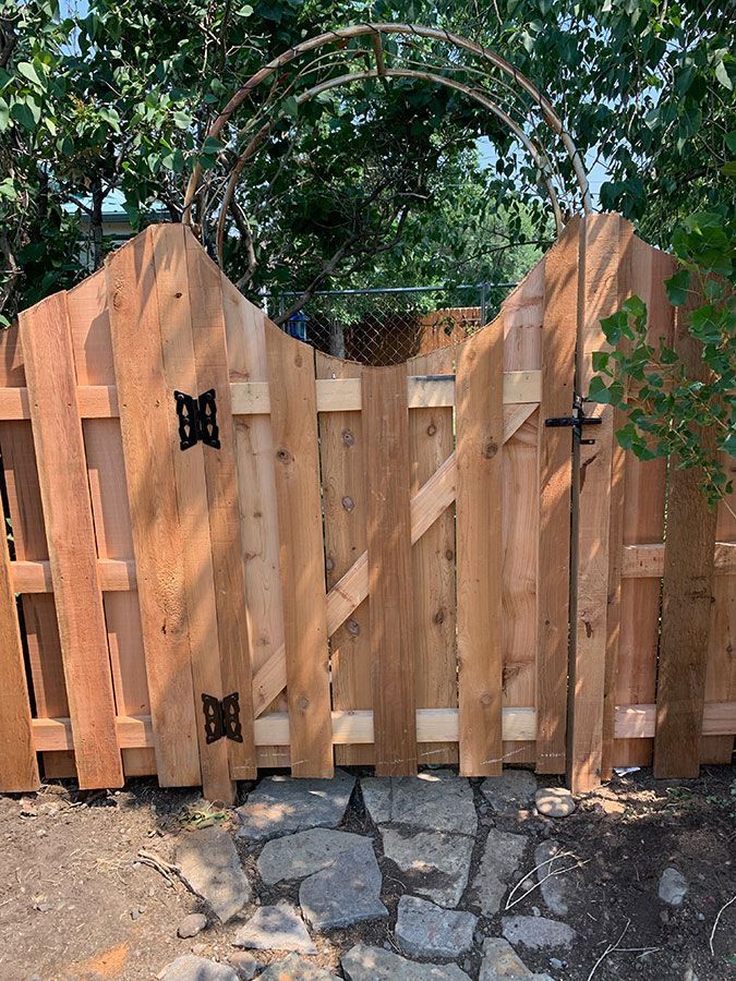 A wooden fence with a gate in the middle of it.