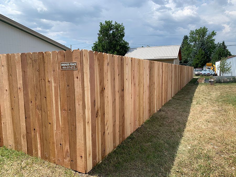 A wooden fence is sitting in the middle of a grassy field.