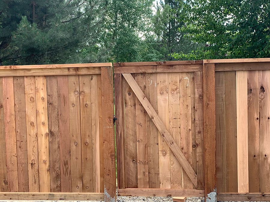 A wooden fence with a gate in the middle of it.