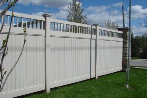 A white fence is sitting on top of a lush green lawn.