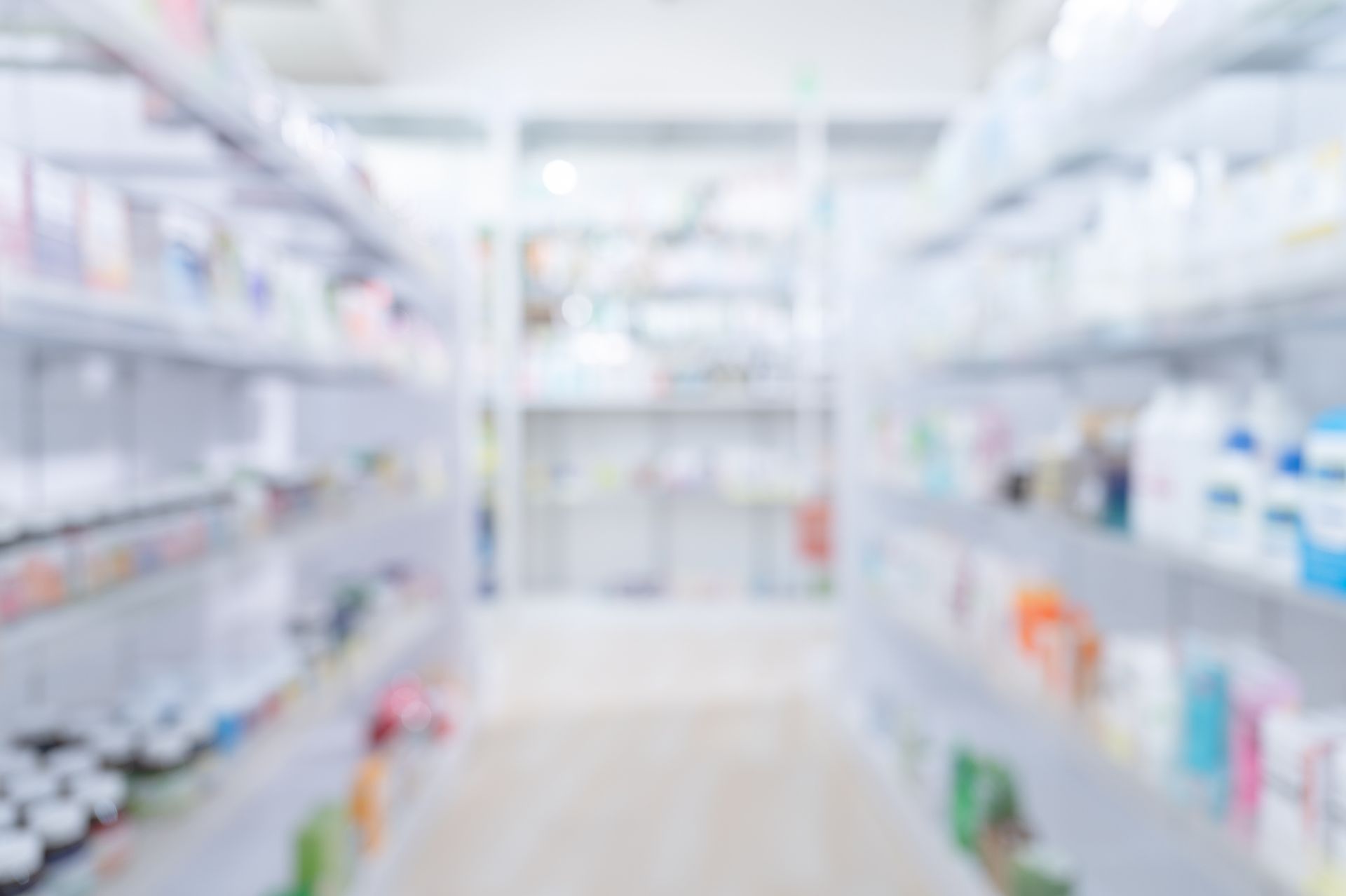 Un'immagine sfocata di una farmacia con scaffali pieni di medicinali.