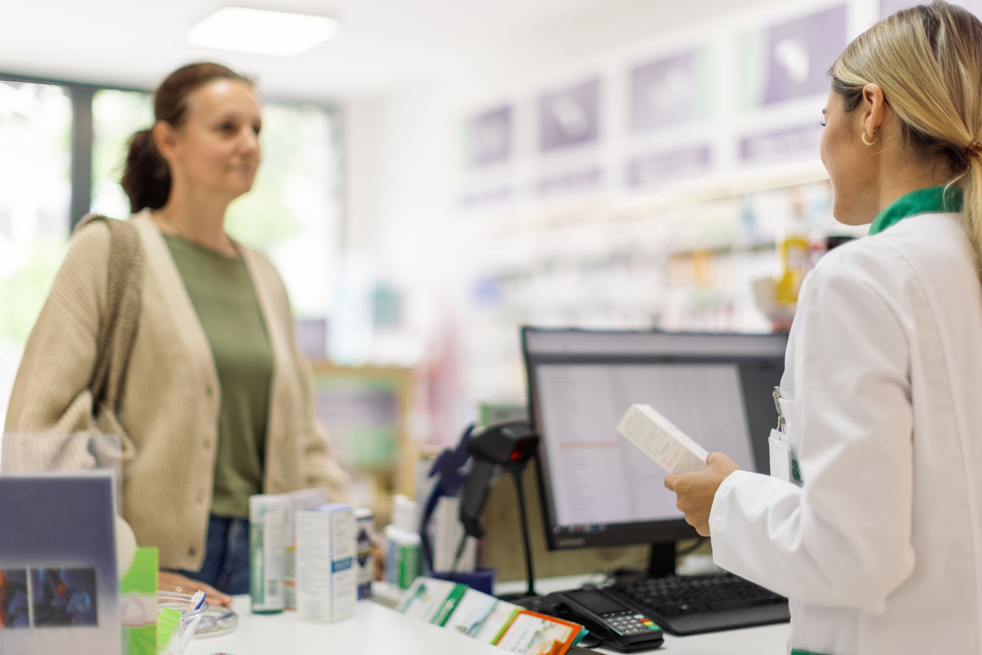 Una farmacista parla con una donna in farmacia.