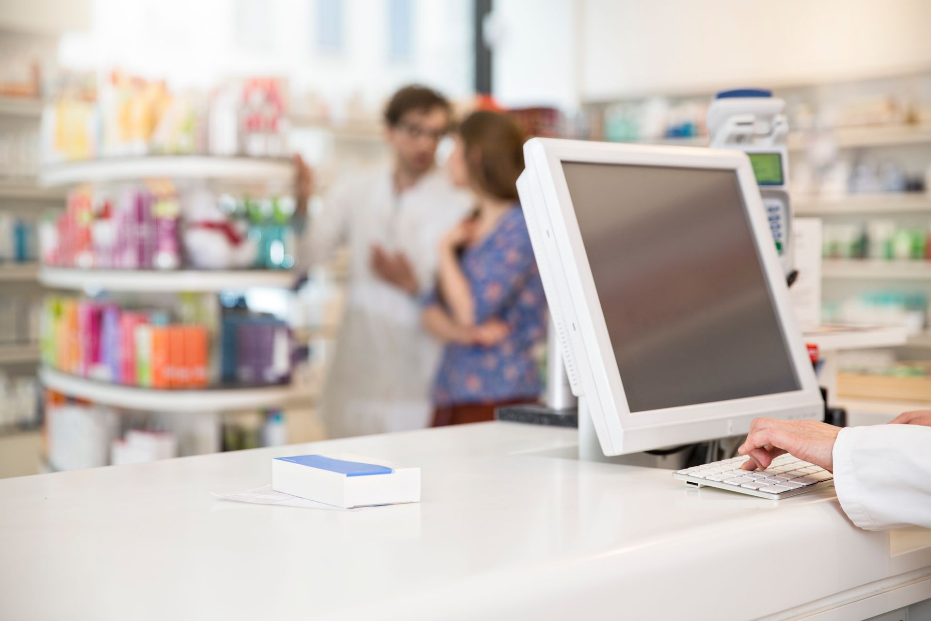 Un farmacista sta usando un computer in una farmacia.