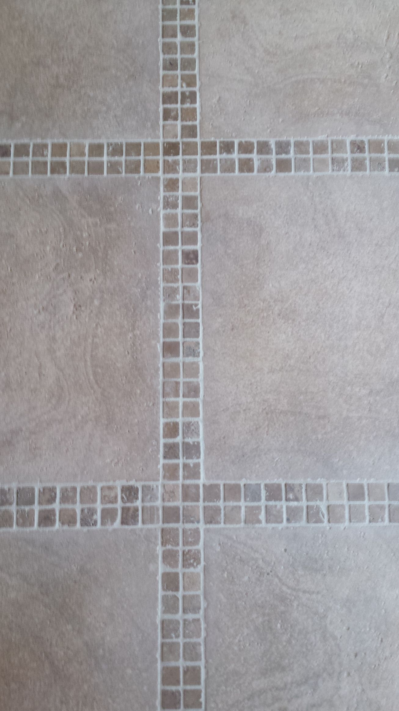 A black and white tiled floor in a bathroom with a drain.