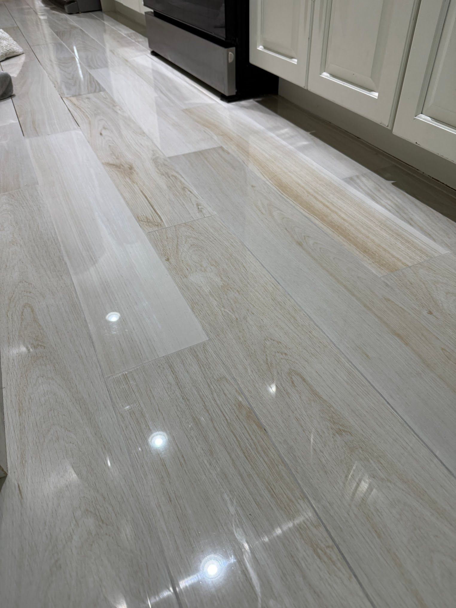 A kitchen floor with white cabinets and a refrigerator.