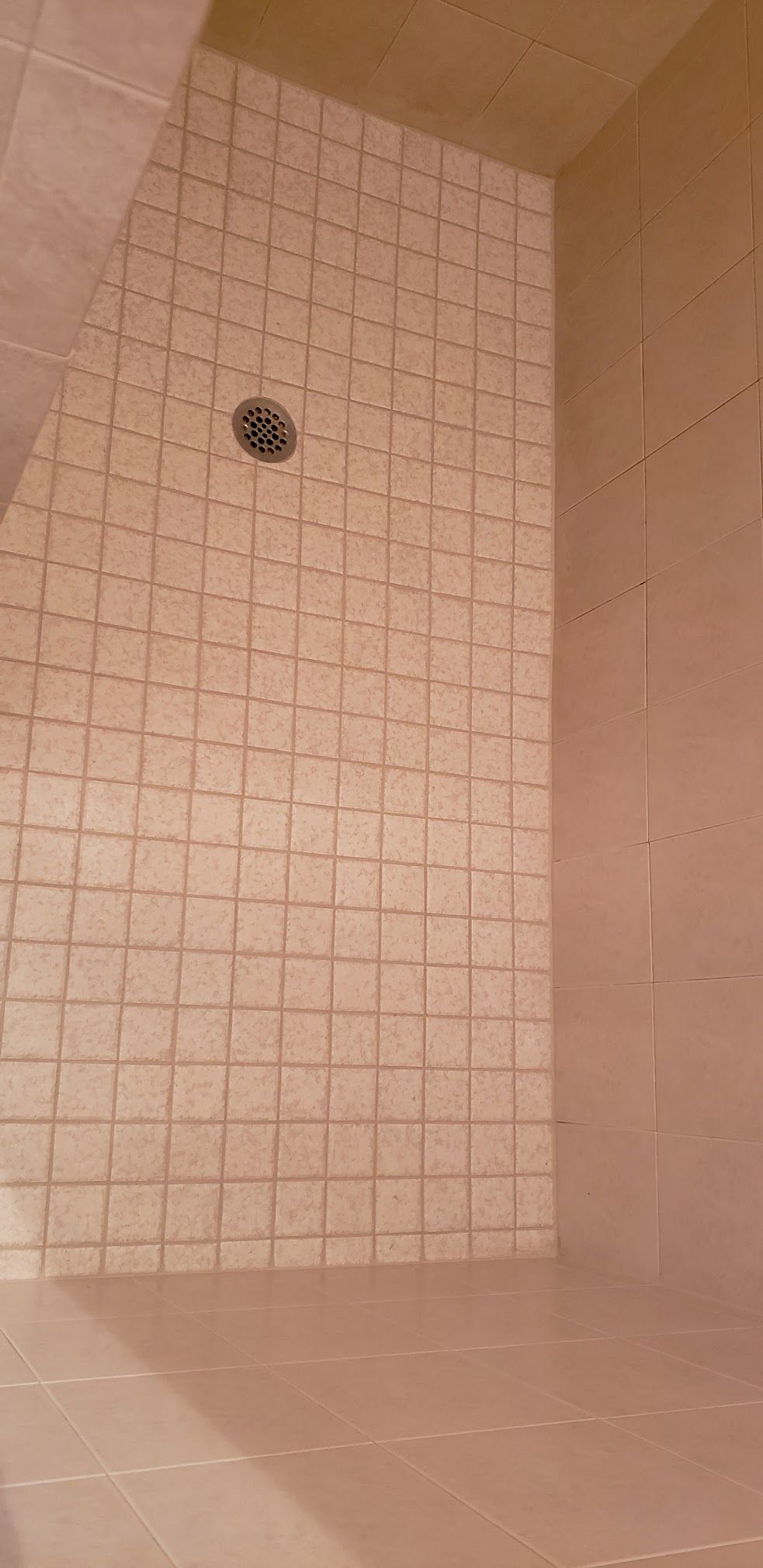 A shower stall with white tiles and a shower head.