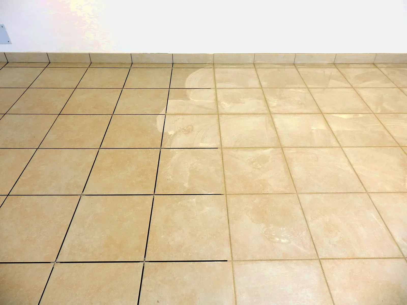 A tiled floor with a white wall in the background