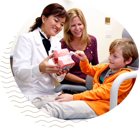 Dr. Pham showing a teeth model to a child