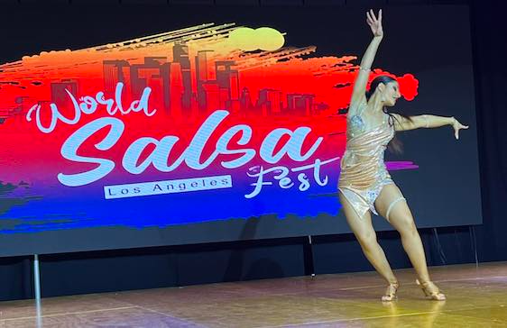 Woman dancing salsa on stage at the World Salsa Fest in Los Angeles.