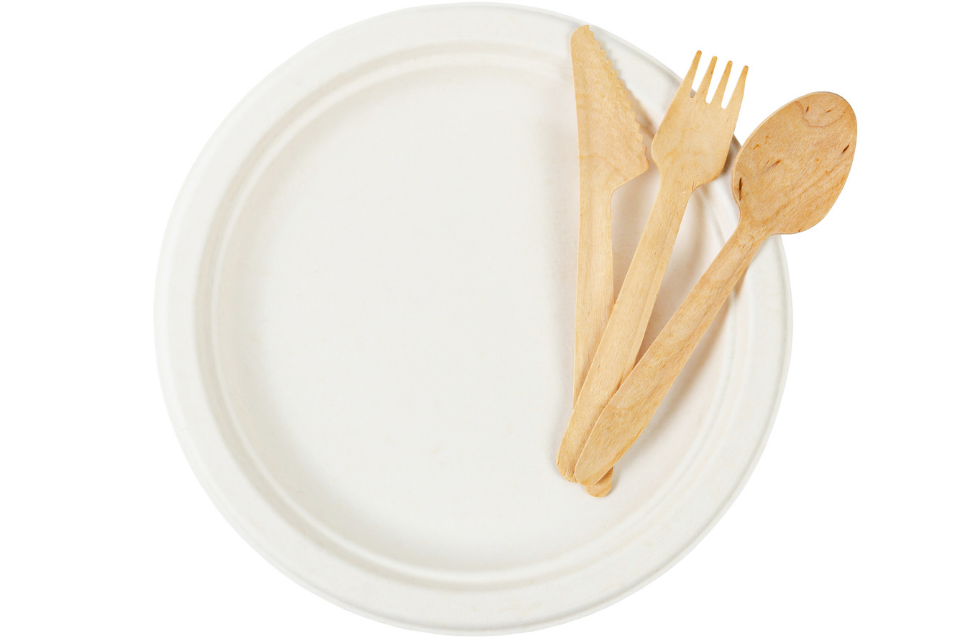 A white plate with wooden utensils on it.
