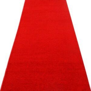 A long red carpet is sitting on a white surface.