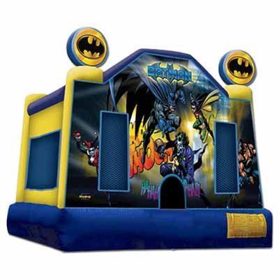 A blue and yellow bouncy house with a batman theme on it.