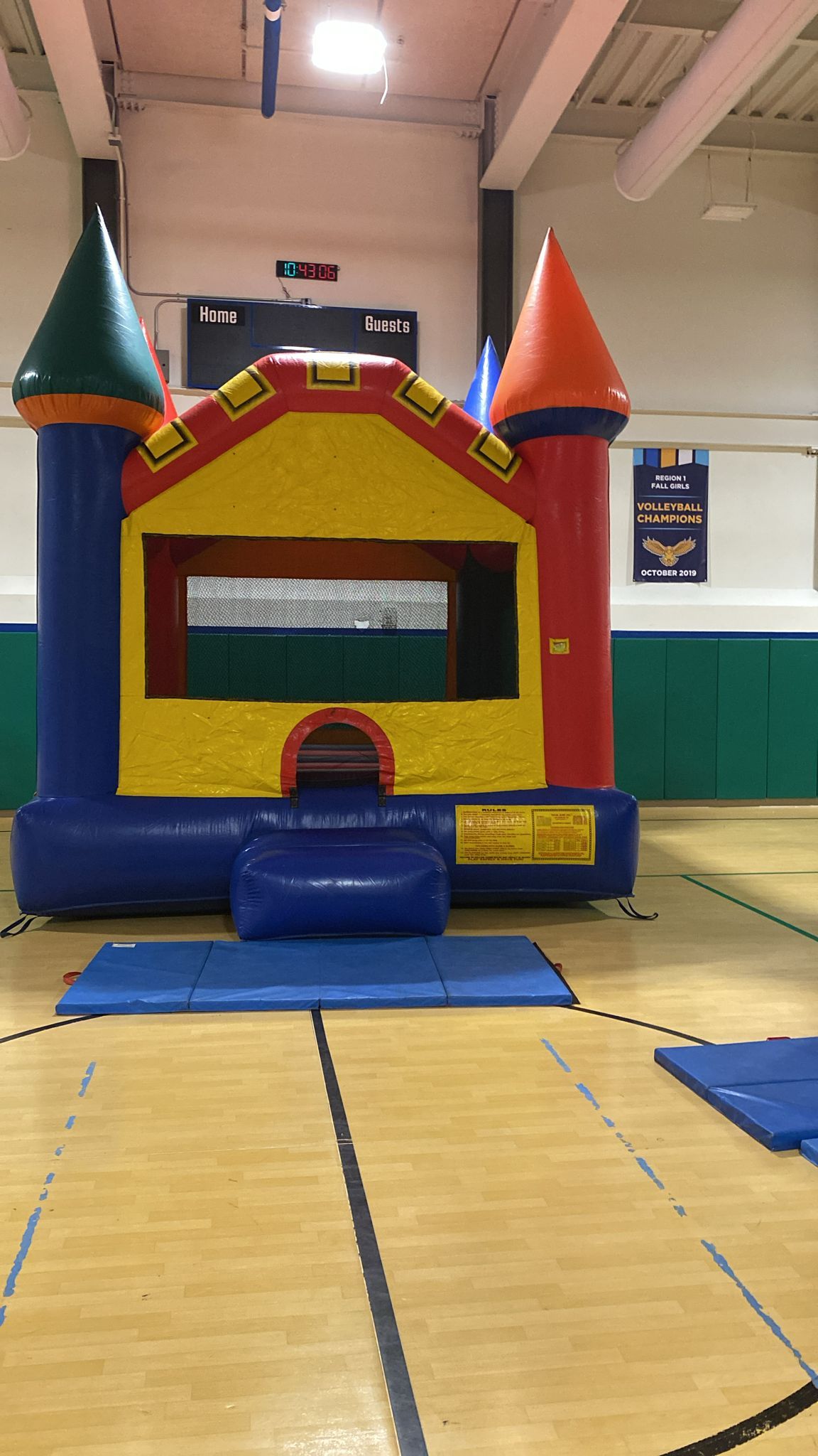 A bouncy house is sitting in the middle of a gym.