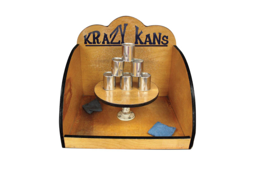A wooden display with cans stacked on top of each other and a sign that says Krazy Kan's