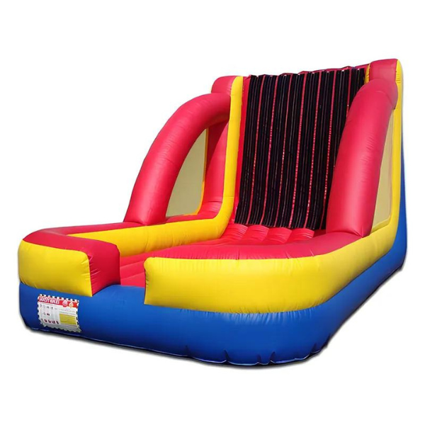 A red yellow and blue bouncy house with a warning label on it
