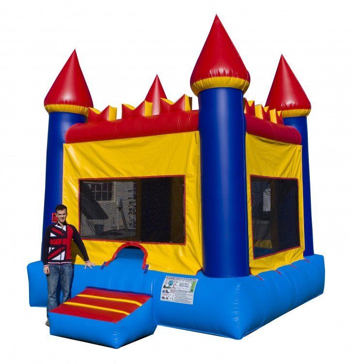 A man is standing in front of a bouncy house that looks like a castle